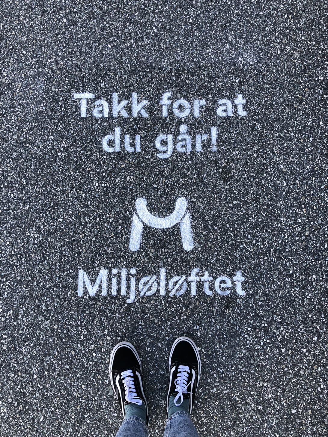 Stensil på asfalten med teksten «Takk for at du går!» og Miljøløftet-logoen, med et par sko synlig i forkant.